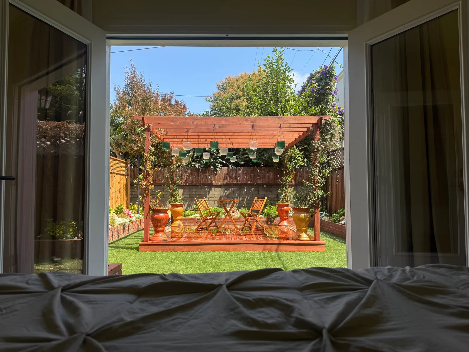 A view from the bedroom through open doors to the garden pergola