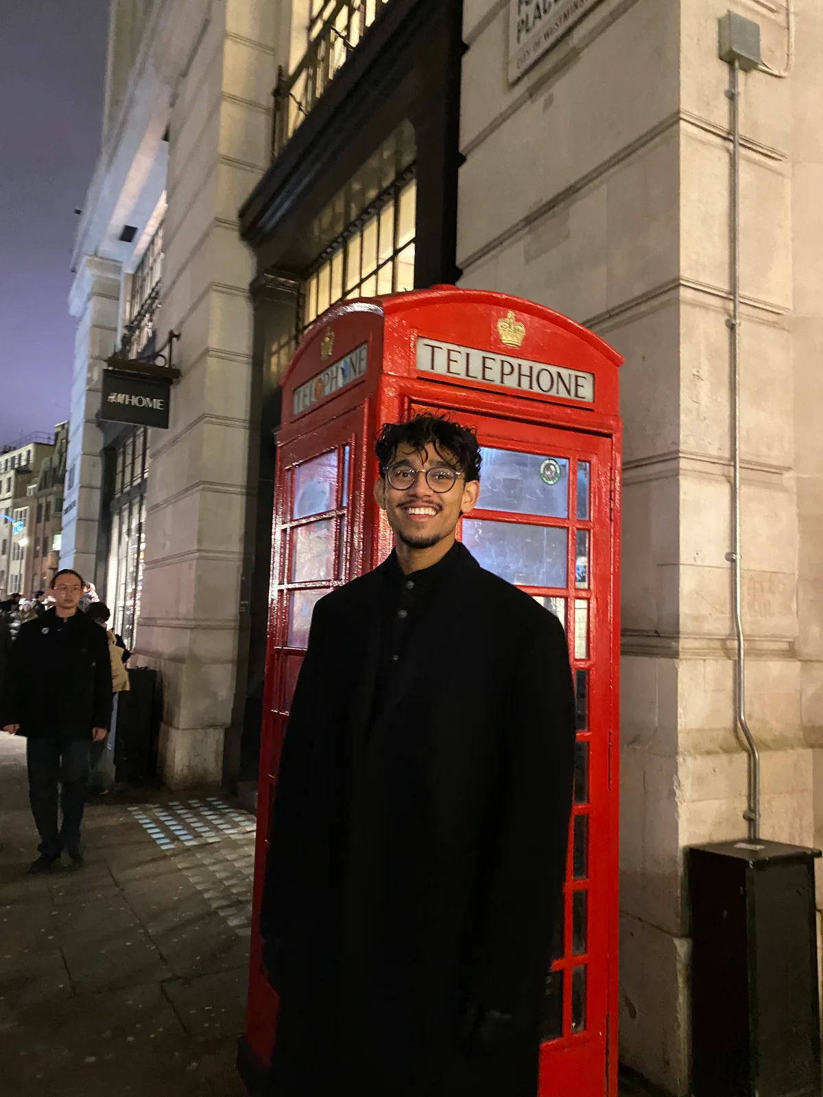 Nabeel Thotti beside a red telephone box in England